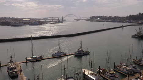 Newport-Oregon,-Kai-Mit-Festgemachten-Booten-Und-Yakina-Bay-Bridge-In-Der-Ferne,-Drohne-Aus-Der-Luft-4k