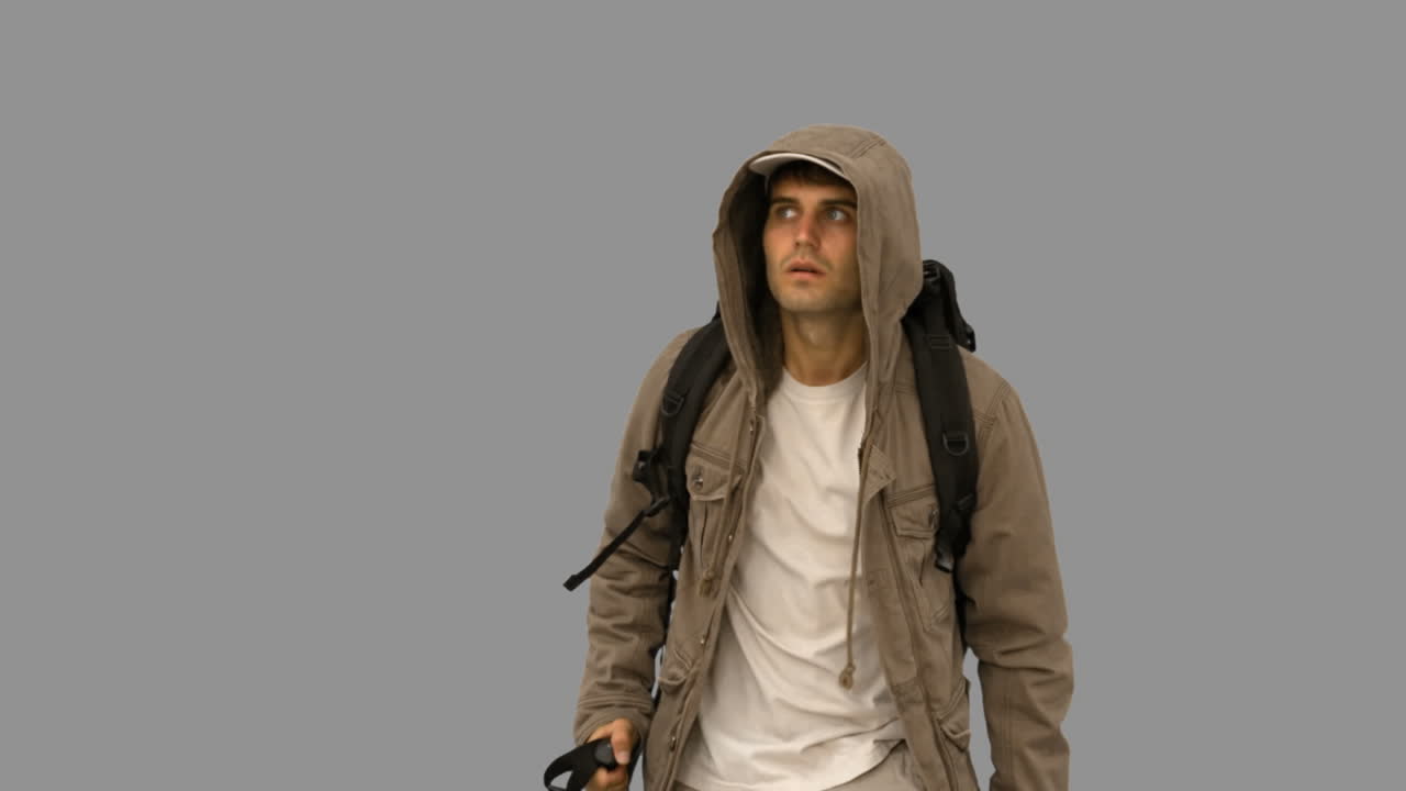 Attractive man with a coat trekking on grey screen