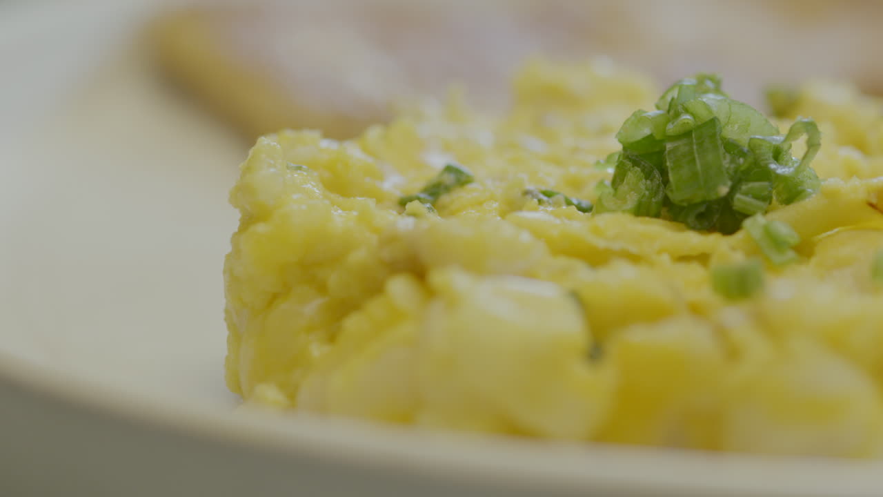 Close-up of a traditional Ecuadorian mote pillo, prepared with cooked corn scrambled with egg and finely chopped scallions