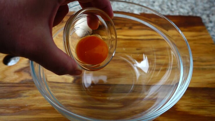 Falling of a yolk in a bowl. Slow motion