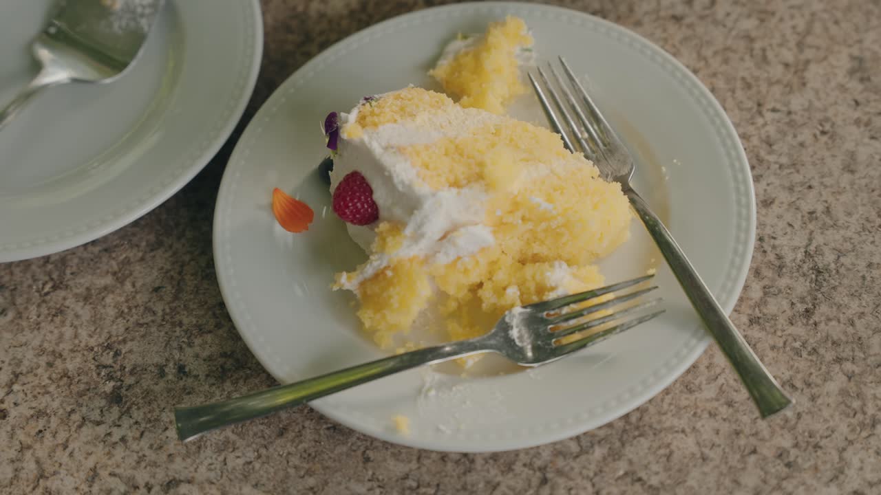 Piece of sponge cake with cream and fruit on white plate
