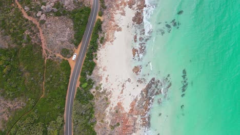 top down drone view of van parked on the side of scenic winding road