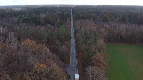 Driving-cars-at-a-straight-country-road-until-the-wide-horizon,-filmed-by-a-drone-in-4k