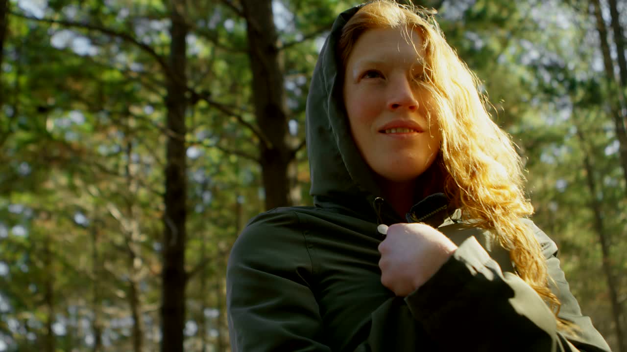 Frau im Hoodie steht im Wald 4k