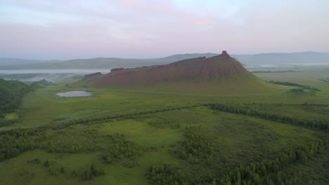 aerial view of a mountain with fog and a lake