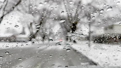 Schnee-Landet-Auf-Einem-Fenster-Und-Schmilzt,-Wenn-Es-Draußen-Schneit