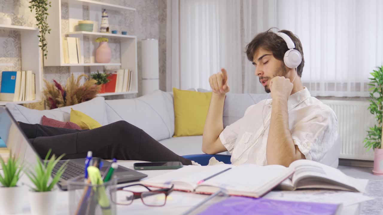 젊은 남자가 헤드폰으로 음악을 듣고 꿈을 꾸고 있습니다.