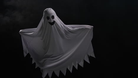 niño vestido con disfraces de fantasma trucos o tratamientos en halloween asustando a la gente corriendo contra un fondo negro 1