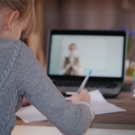 girl learns at home uses laptop for online classes during quarantine