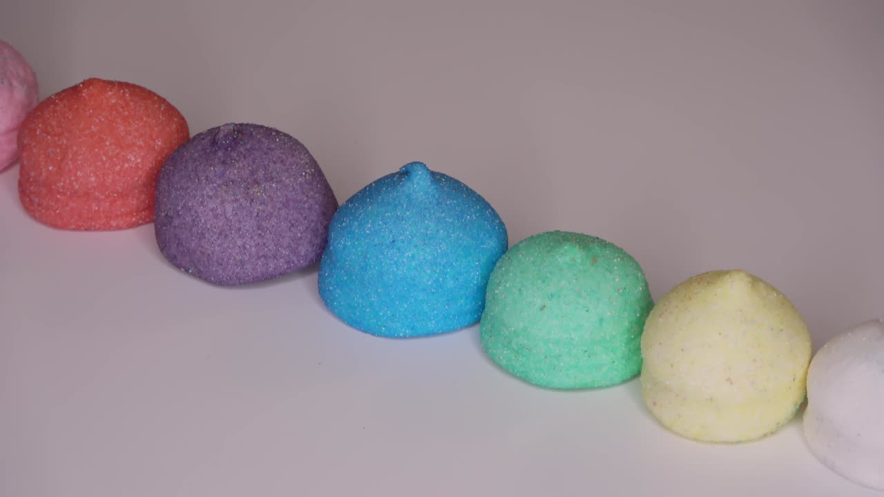 очень красочные конфеты с маршмеллоу на белом фоне, вращающиеся в круге - закручиваемые кадры.