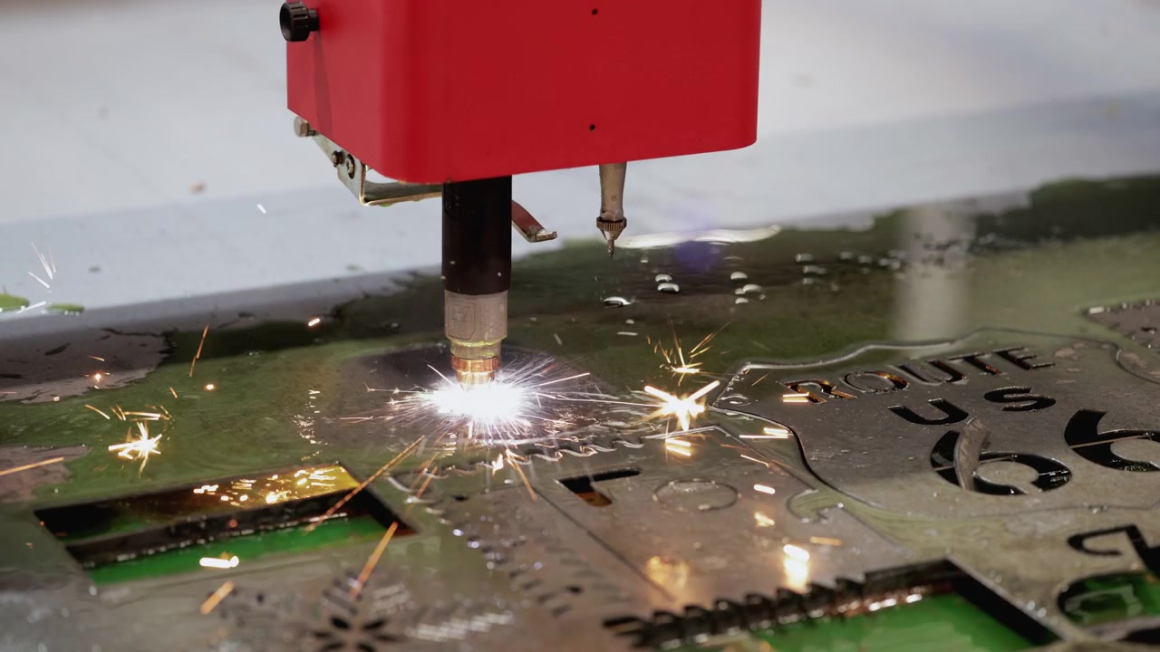 Macchina industriale da taglio al plasma CNC che taglia una lastra di metallo.