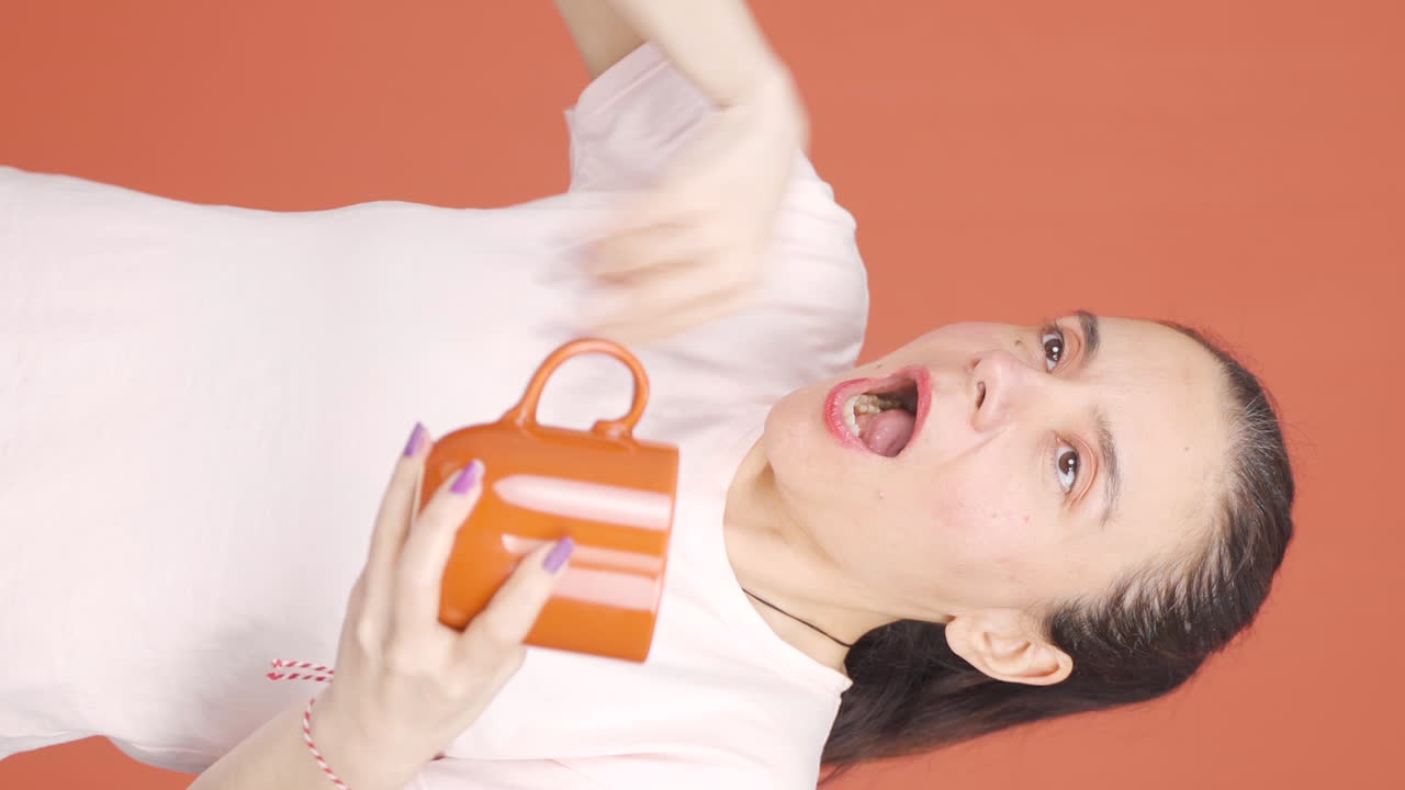 Vertical video of The woman's mouth is burning from the hot drink.
