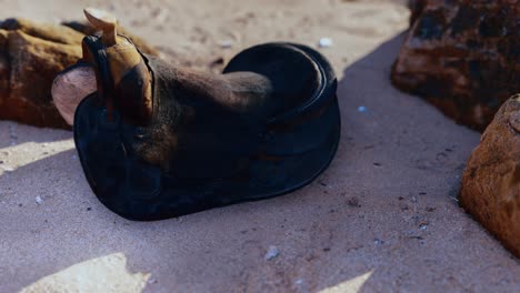 old horse saddle on sand beach