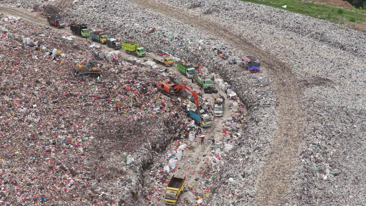 Luftaufnahme von Müllwagen auf einer Mülldeponie, einem Ort der Umweltverschmutzung