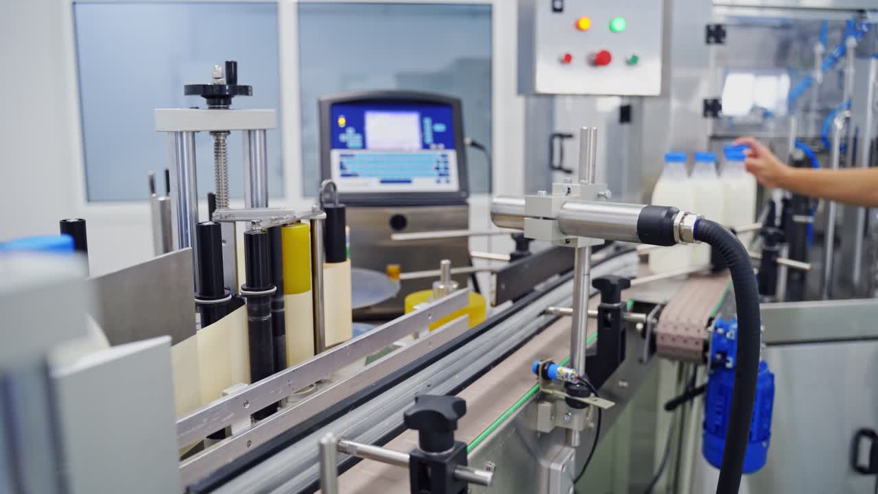 ?onveyor with milk bottles. Blue covers on plastic bottles with milk inside at factory