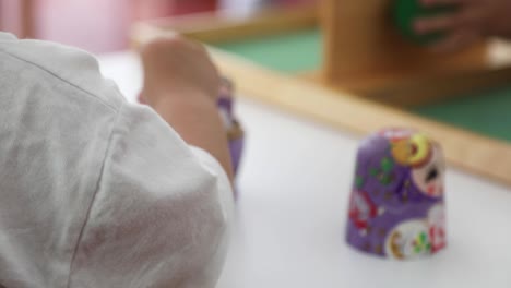 child playing and learning with a mamushka purple toy