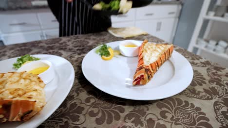 scooping veggies onto lobster tail plate in kitchen, gourmet preparation