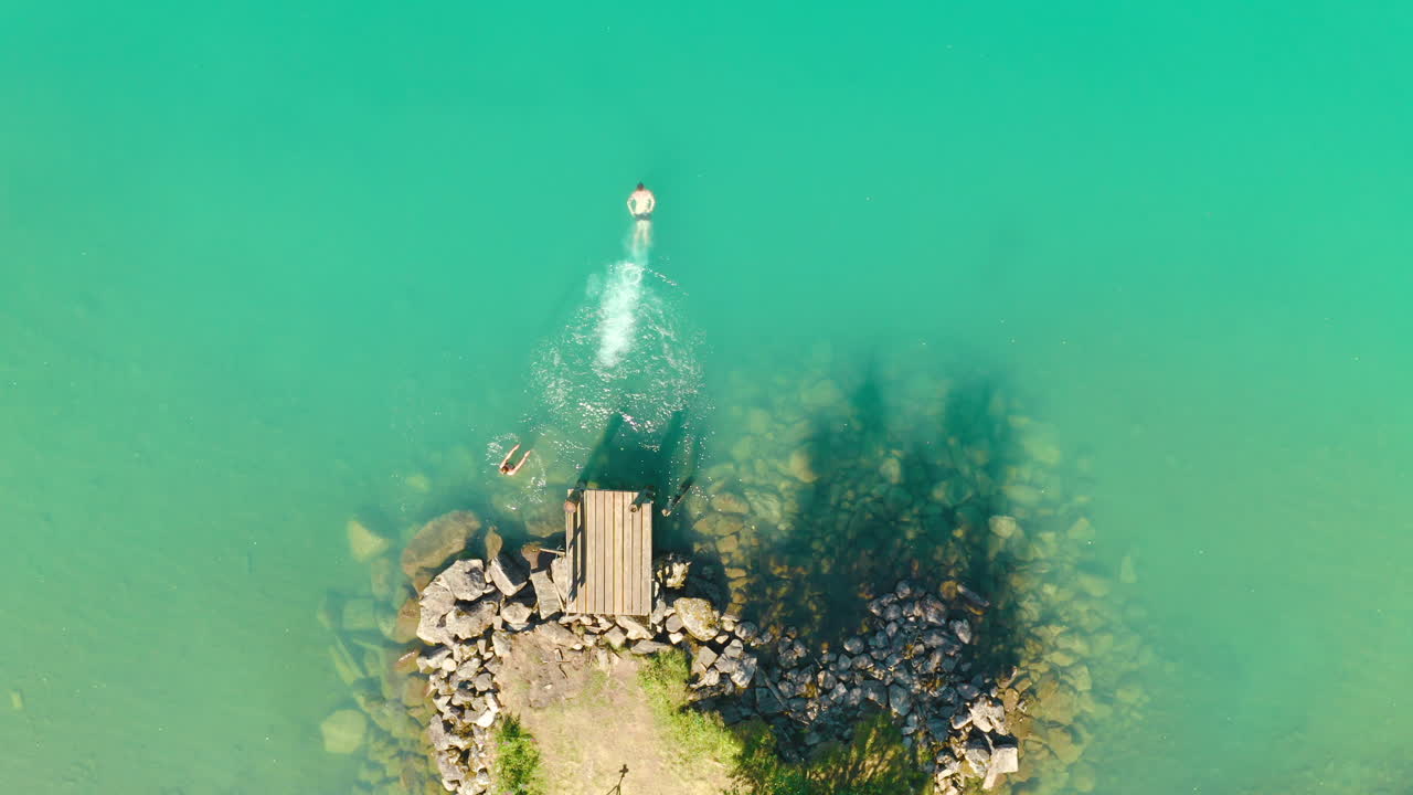 노르웨이, 스트린, 로엔에 있는 보달 빙하의 부두에서 친구들과 다이빙하고 수영하는 남자의 최고 전망