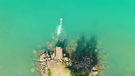 Top-View-Of-A-Man-Diving-And-Swimming-With-Friends-At-The-Pier-In-Bodal-Glacier-In-Loen,-Stryn,-Norway