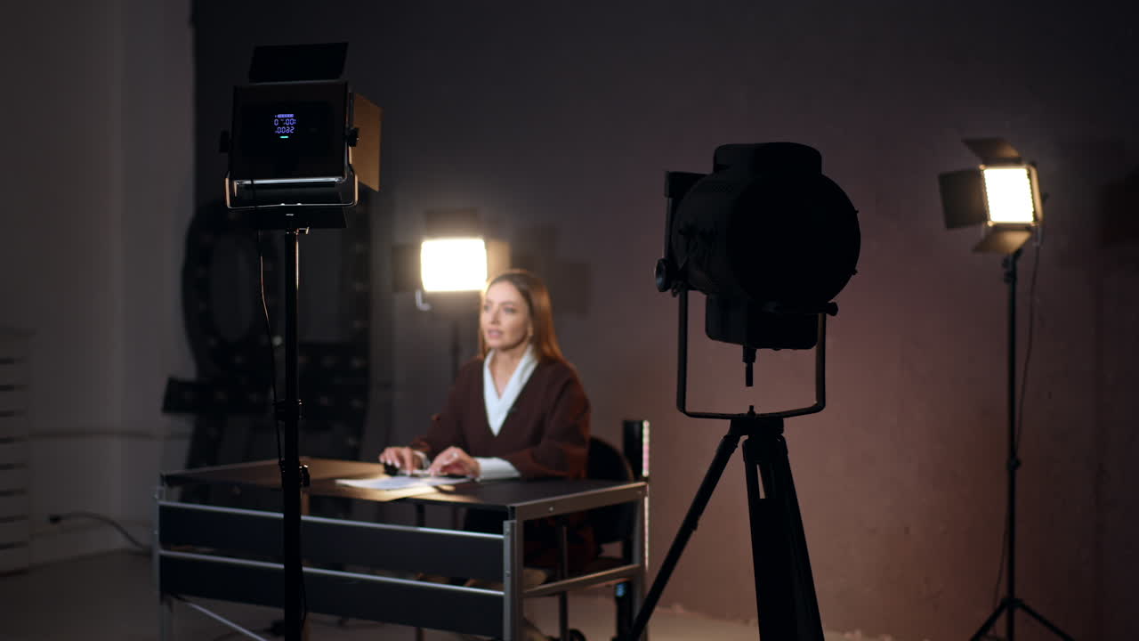 Studio footage of a woman sitting and speaking in front of camera. Video content creation for a blog or program.