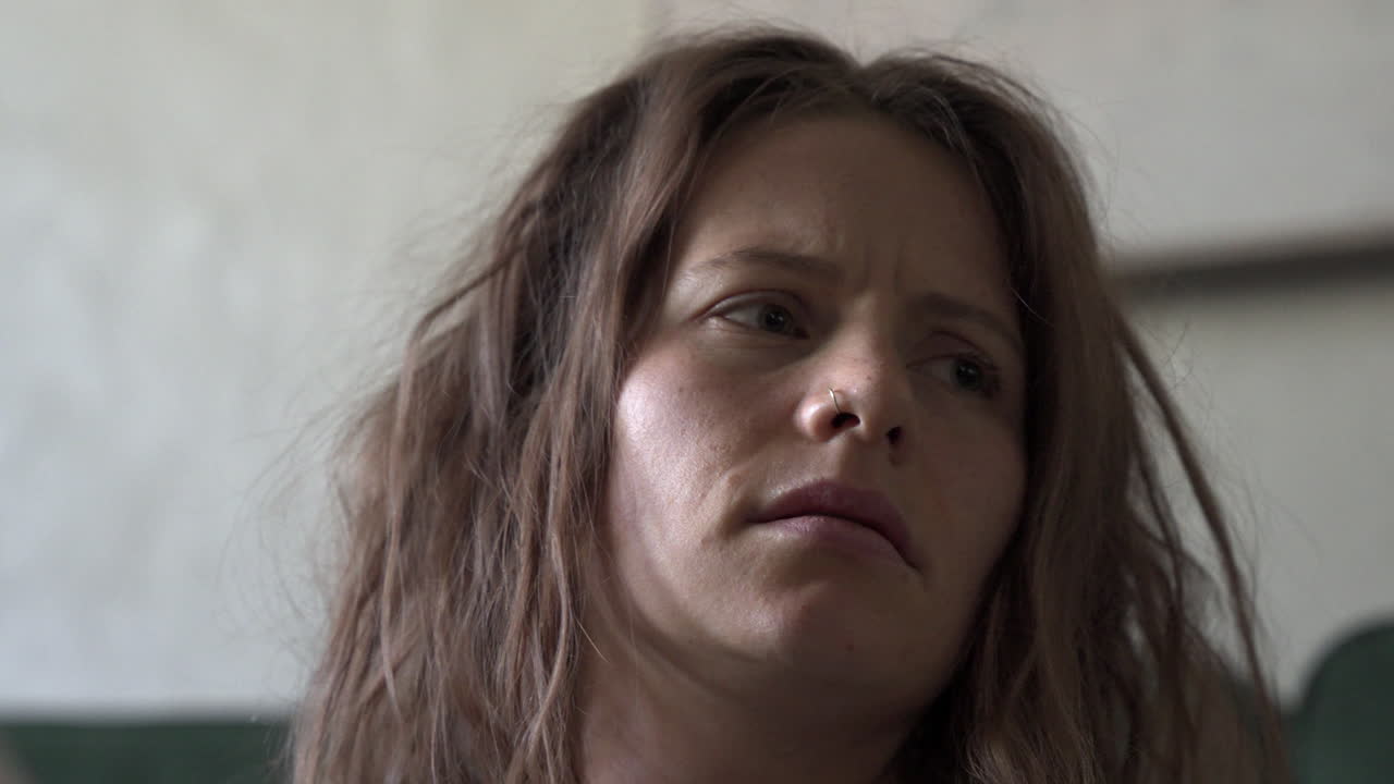 A close-up shot of a woman reading a letter. After finishing, she moves the letter down and gazes into the distance. The focus pulls from the letter to her face, beautifully captured in slow motion.