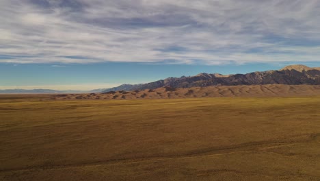 Grandes-Dunas-De-Arena-Montañas-Puesta-De-Sol-Aéreo-Pan-Shot-4k