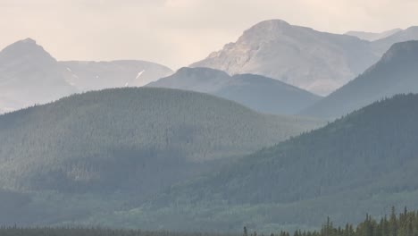 Wildfire-smoke-obscures-the-Rocky-Mountains-as-a-drone-flies-left-to-right-in-Alberta,-Canada