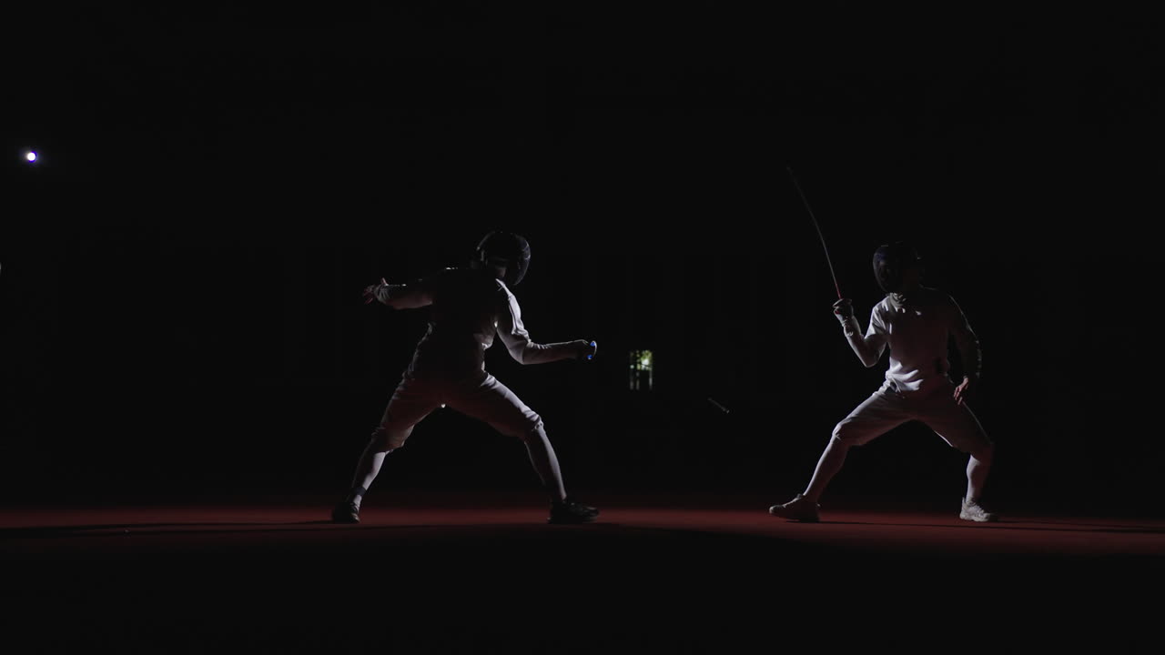 Two fencers in action during a fencing competition