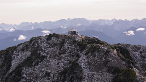 viewing structure on top of mountain peak and view of alps in background