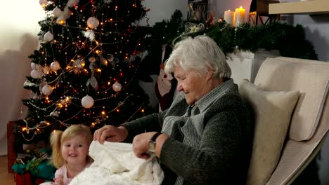 la abuela teje un calcetín mientras está sentada en una silla