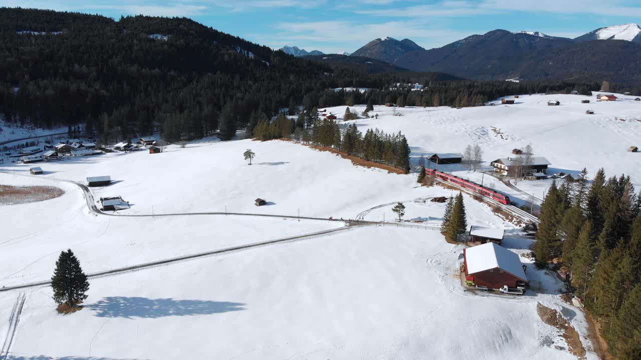 Aerial: train near Mittenwald emerging among trees.