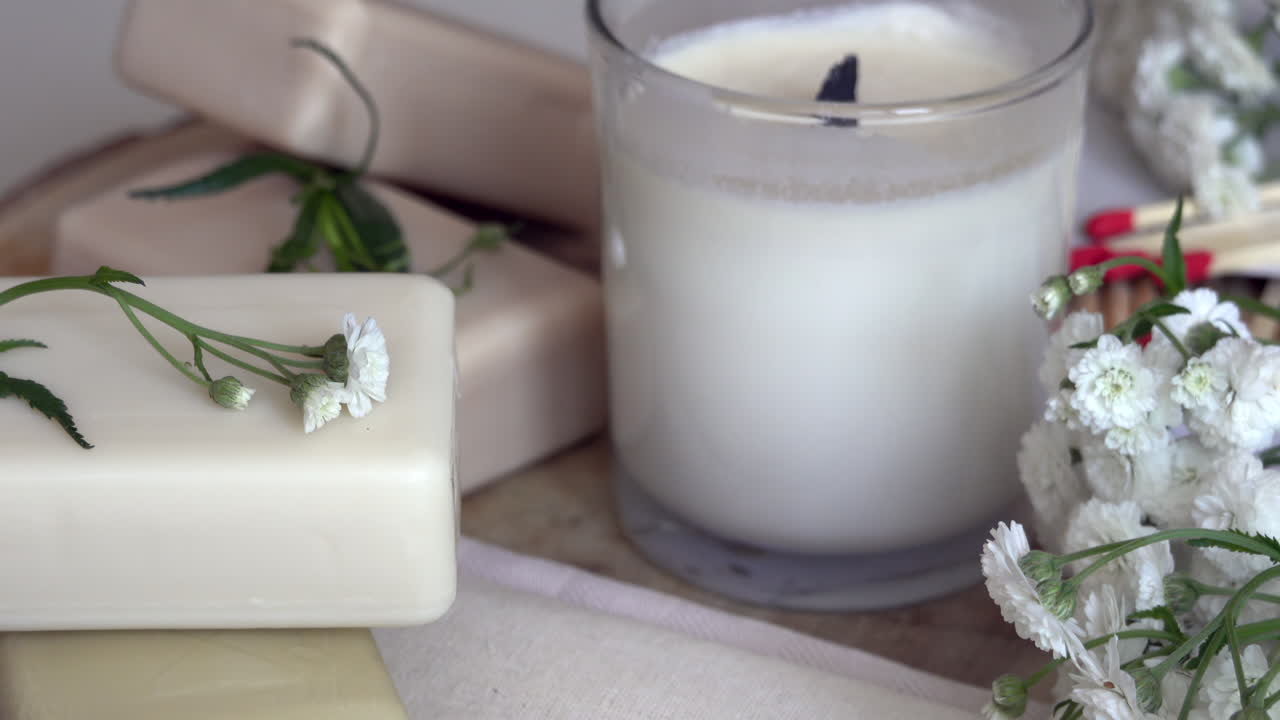 Close up of white candles and soaps on a wooden surface