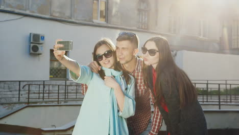 los amigos hipster se ríen selfie hacen caras graciosas en los rayos del sol sobre un fondo de un