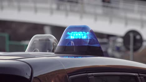 hand held footage of a switched on blinking blue light on a car roof