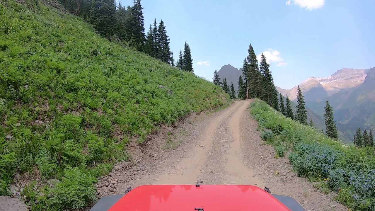 좁은 오프로드 트레일 트레일에서 차량 후드 위의 pov는 산쪽으로 잘립니다.