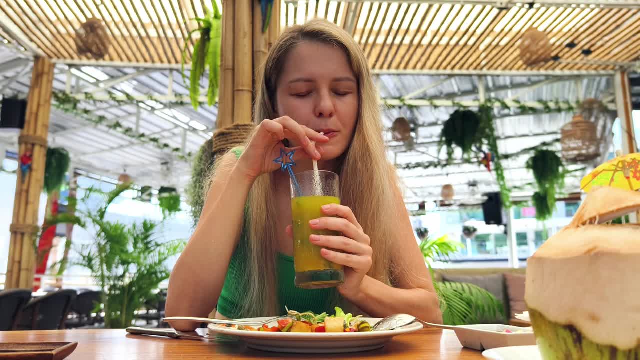 mujer disfrutando de un almuerzo tropical al aire libre