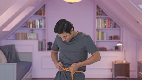 Happy-Indian-man-measuring-waist-using-inch-tape