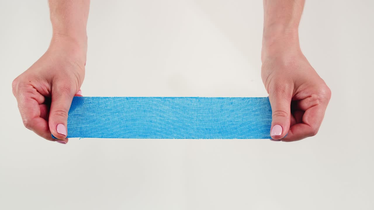 Kinesiology medical taping, doctor Physical therapist applying elastic surgical tape to patient body, treating injured knee young athlete.Post traumatic rehabilitation, sport physical therapy recovery