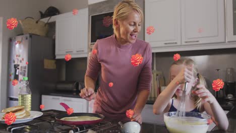 animation of flowers over happy caucasian mother and daughter cooking together