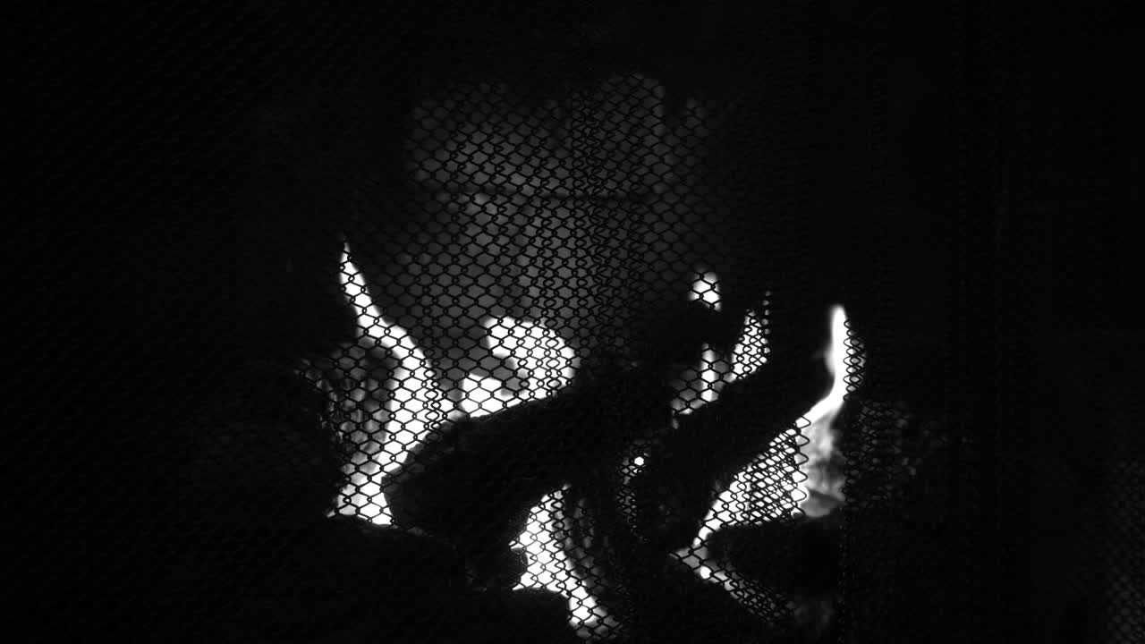 Film noir fireplace black and white fire burning in a hearth close up shot