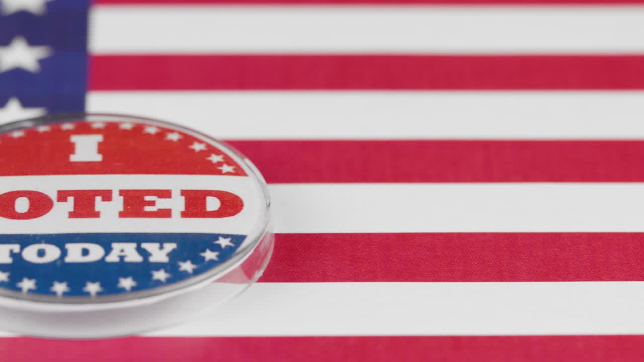 Macro video of I Voted Today button on US flag
