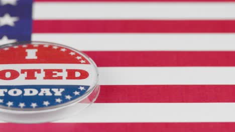 macro video of i voted today button on us flag