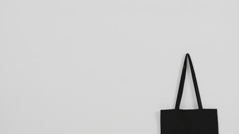 close up of black bag on white background, copy space, slow motion