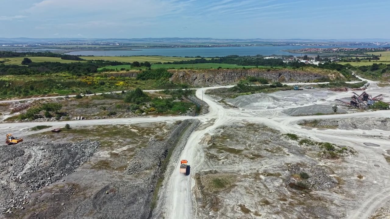 Cava di granito con macchinari e paesaggio sullo sfondo con tempo sereno in un ambiente di lavoro.