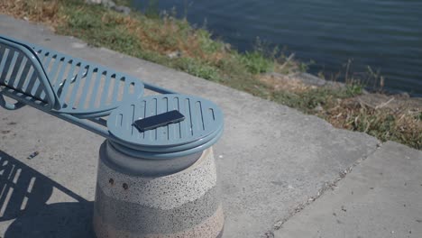 a cell phone on a bench by the water