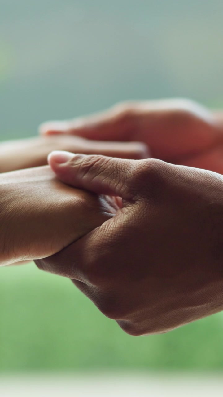 Close-up of Two People Holding Hands in Support