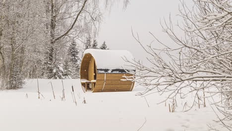 thermowood barrel sauna isolated on snow covered field