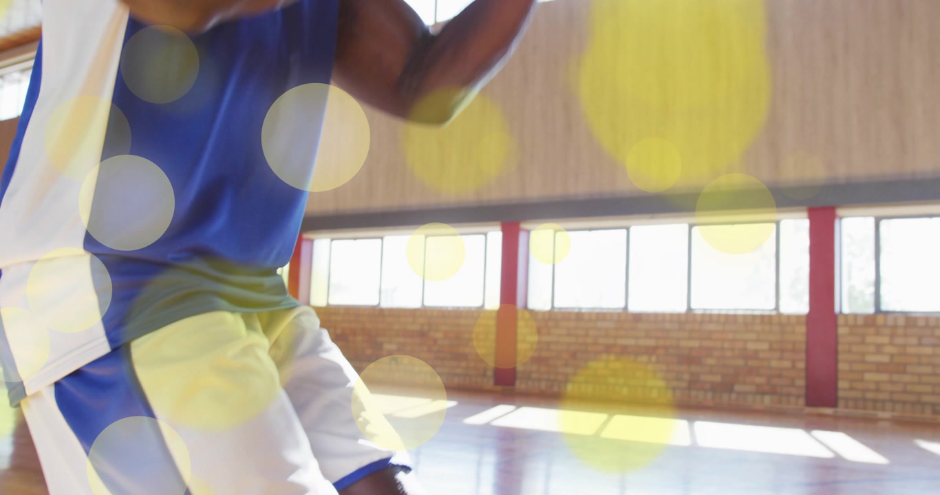 Male athlete initiating dribble bounce on court for jump shot training with animated light circles