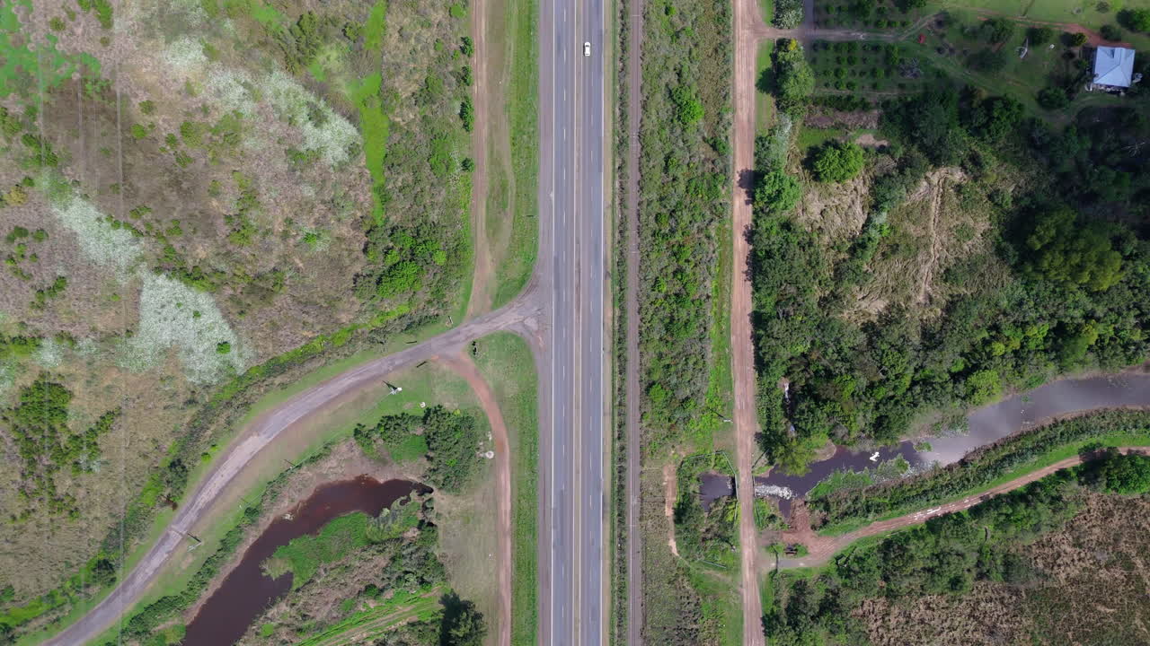 Highway through lush rural landscape seen from above, nature and transportation route
