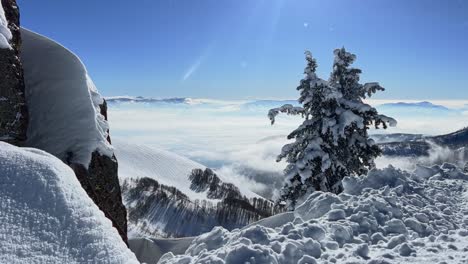 disparo inclinado hacia abajo de una impresionante escena de paisaje de invierno mirando hacia abajo en un valle cubierto de nieve nublada desde la cumbre de una estación de esquí en las montañas rocosas de utah en un brillante día cálido y soleado de primavera